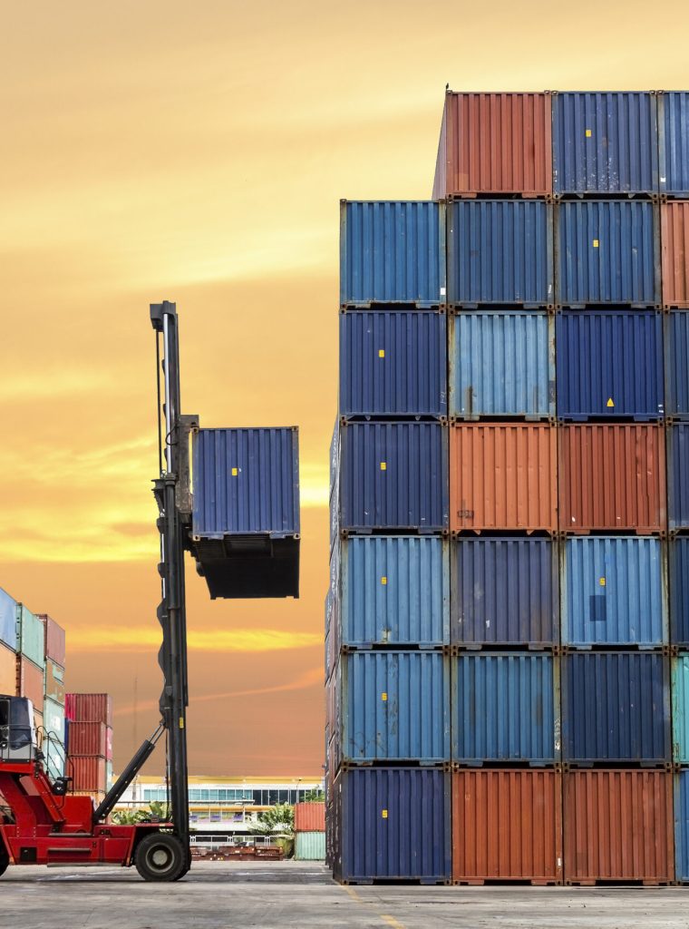 Crane lifting up container in yard